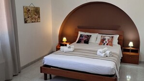 Ein Schlafzimmer mit einem hölzernen Bett, zwei Nachttischlampen, einem Deckenventilator und einem Wandbild.
