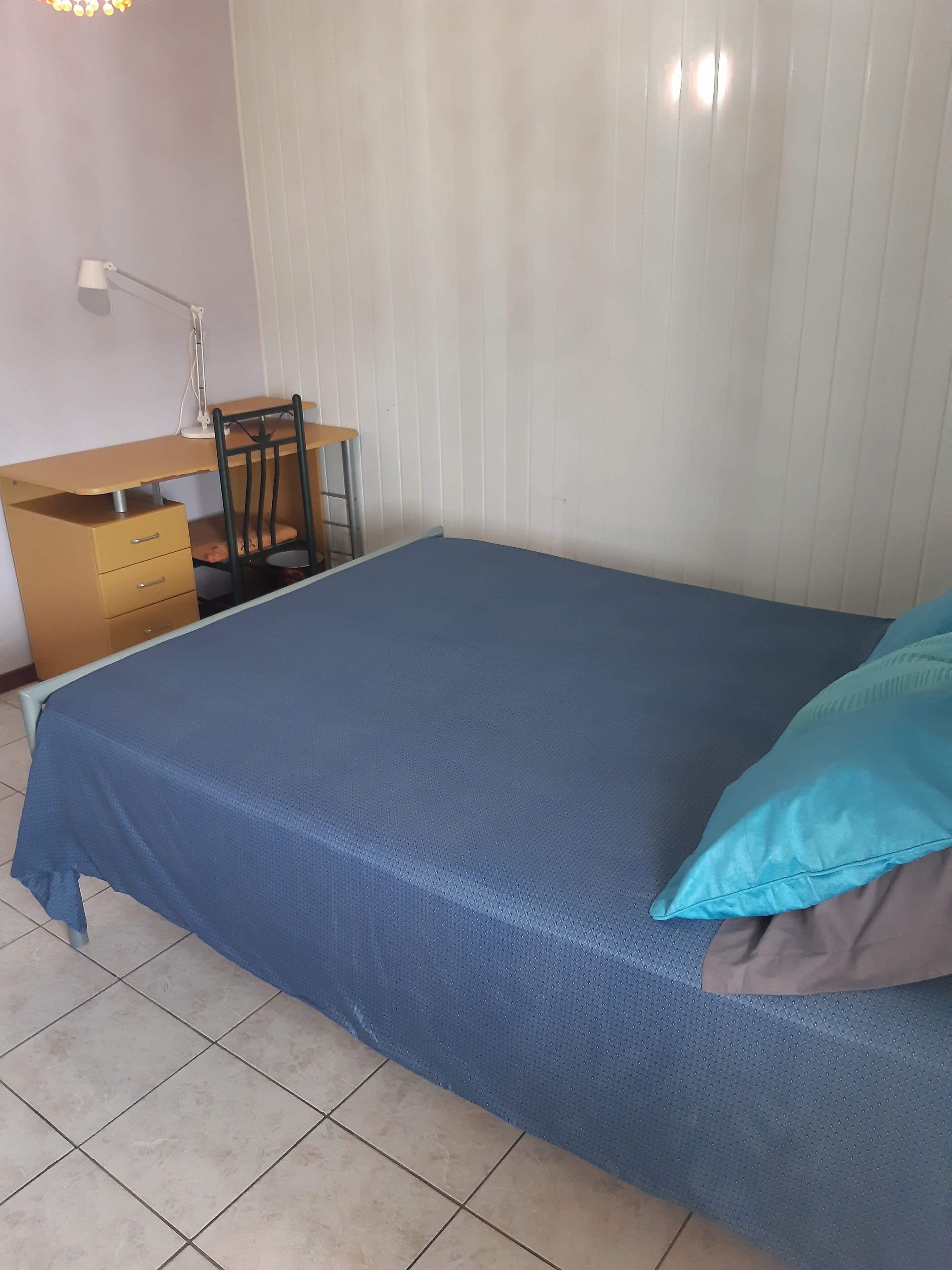 Ein Schlafzimmer mit einem Bett, einem Schreibtisch und einem Stuhl.