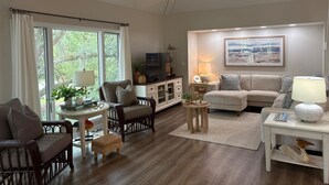 A living room with a sofa, armchairs, a TV, and a dining table. - Popular Spinnaker Beach House! Close to Beach! Amenity access included! (Seabrook Island)