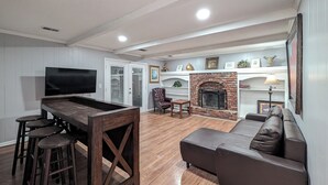 Una sala de estar con televisor, chimenea, sofá y zona de bar.