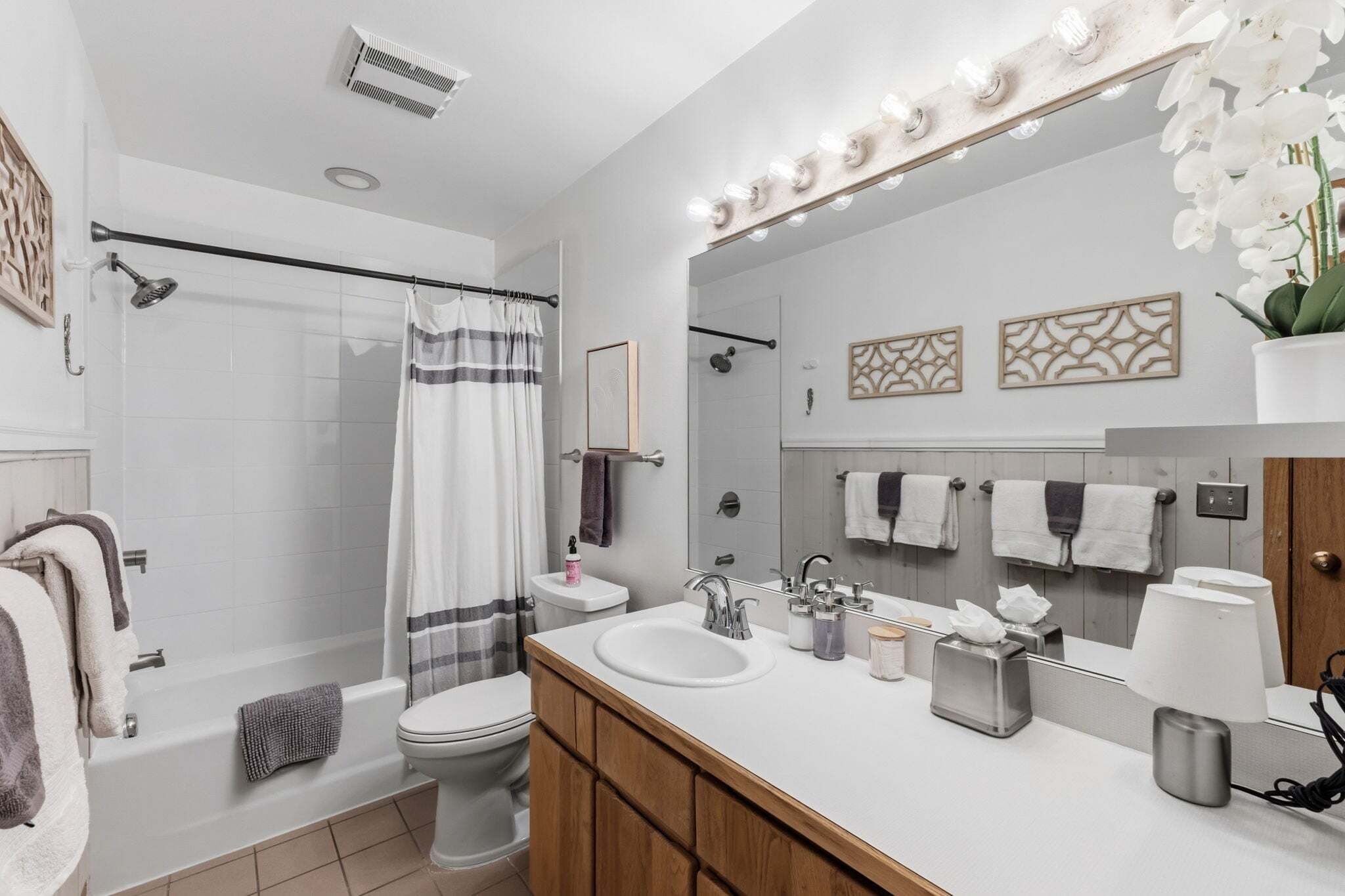 Une salle de bain moderne équipée d’une douche, de toilettes, d’un lavabo et d’un meuble-vasque.