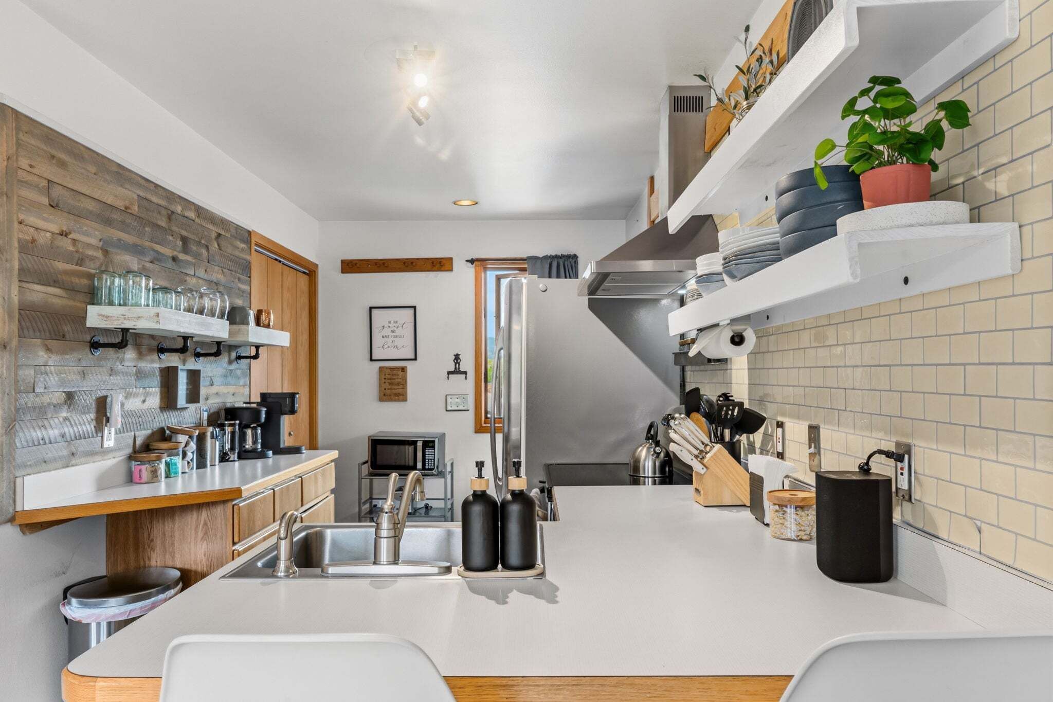 A modern kitchen with a central island, stainless steel appliances, and a variety of storage options.