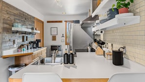 A modern kitchen with a central island, stainless steel appliances, and a variety of storage options.