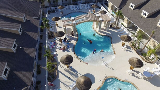 Um resort com várias piscinas, espreguiçadeiras e guarda-sóis.