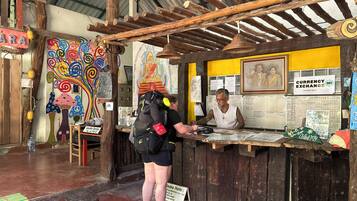 A rustic currency exchange booth with wooden beams, a colorful mural, and a sign for currency exchange.