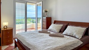 A bedroom with a bed, a nightstand, a dresser, and a balcony with a view. - Beautiful apartment in Labin with WiFi (Labin)
