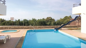 A swimming pool with a slide, a small kiddie pool, and a stone wall. - Beautiful apartment in Labin with WiFi (Labin)