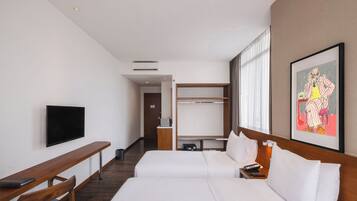 A hotel room with a bed, a TV, a desk, and a wardrobe.