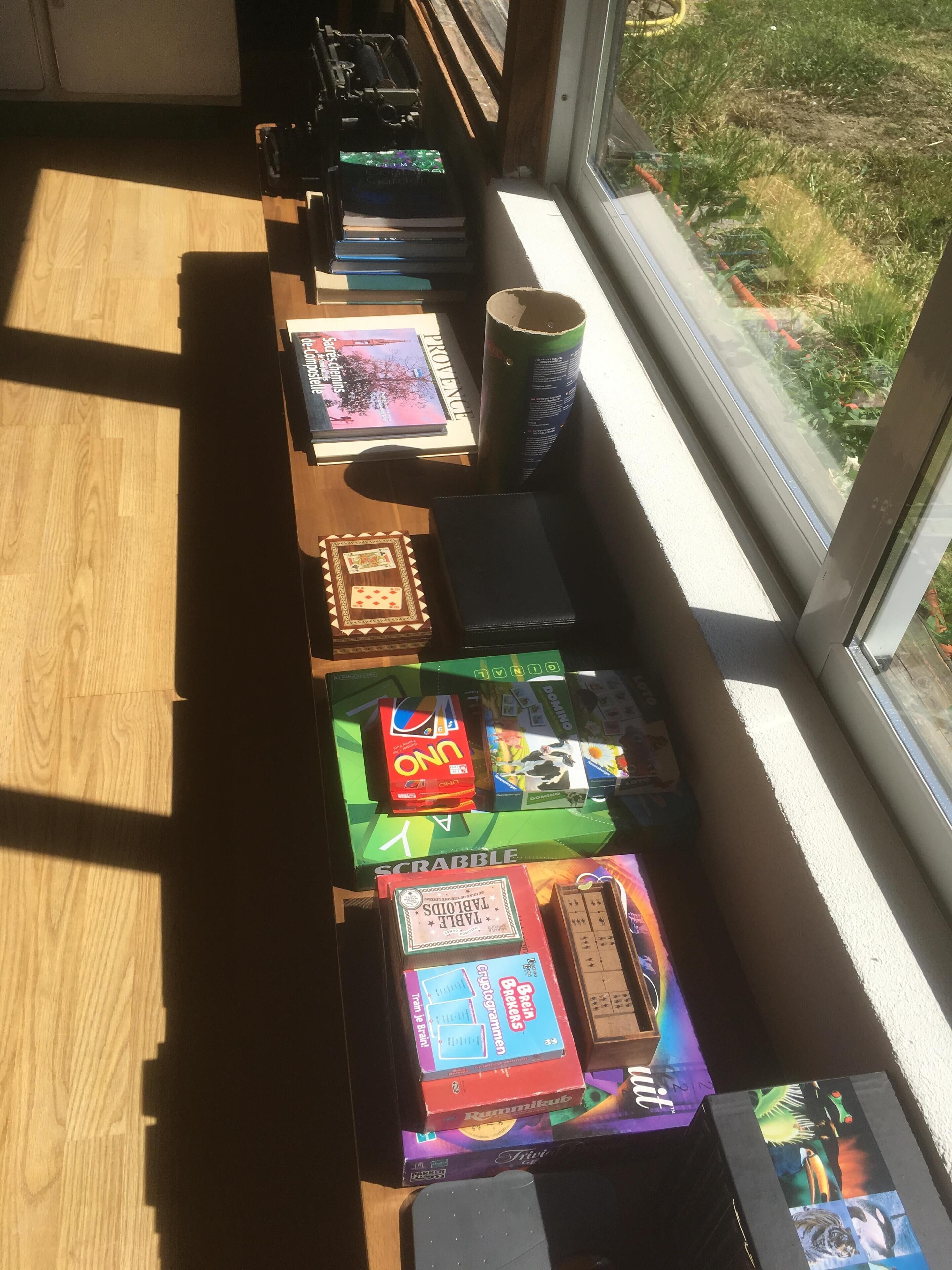 A table with various board games and a box of UNO cards.