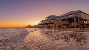 Un hotel frente al mar con varios niveles, pasarelas de madera y vistas al océano.