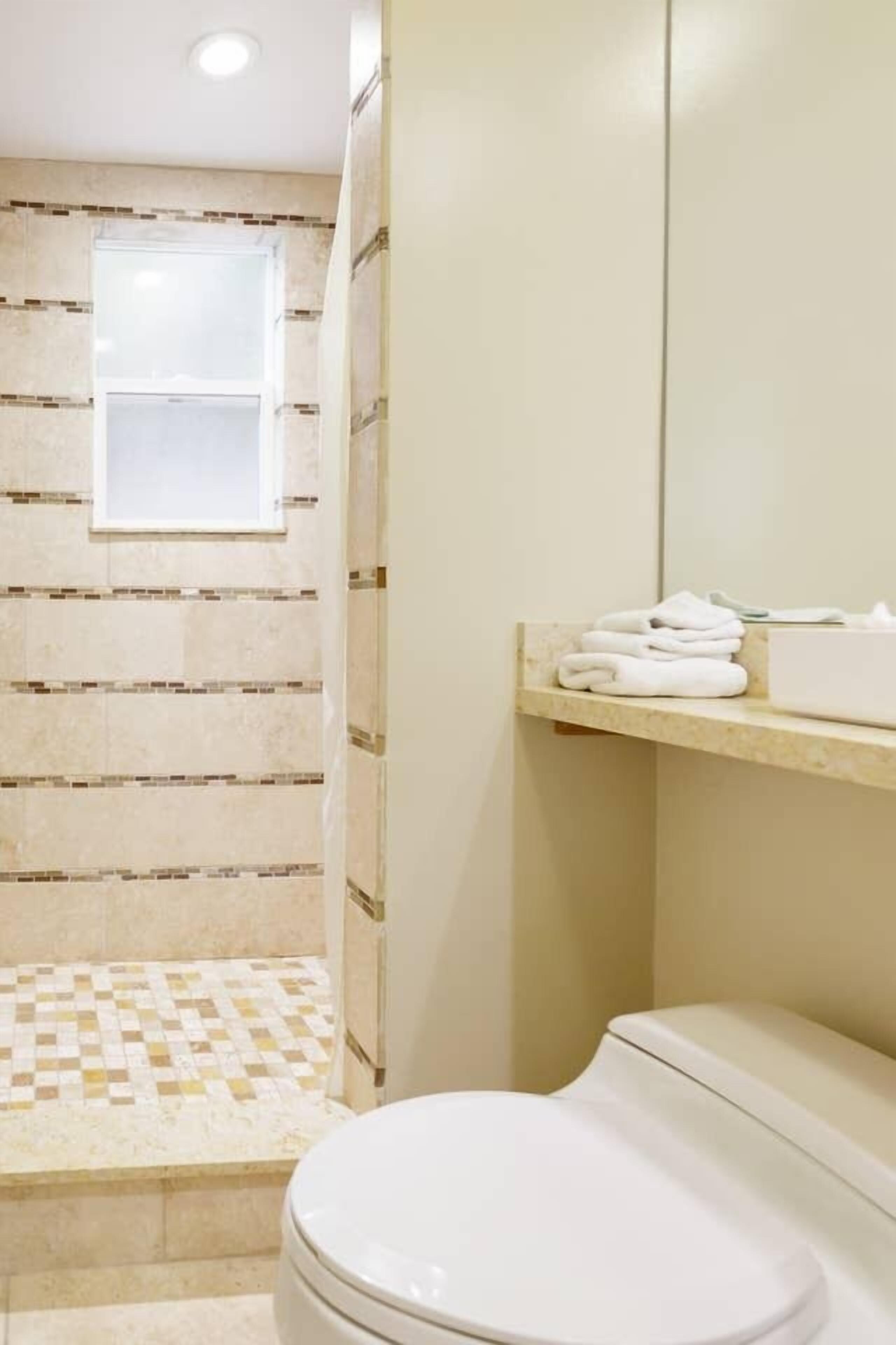 Een badkamer met toilet, wastafel en douche.