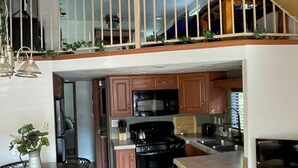 A spacious kitchen with wooden cabinets, a stove, and a dining area with a table and chairs.