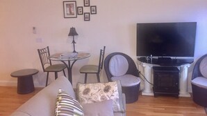 Una sala de estar con sofá, sillones, televisor y chimenea.