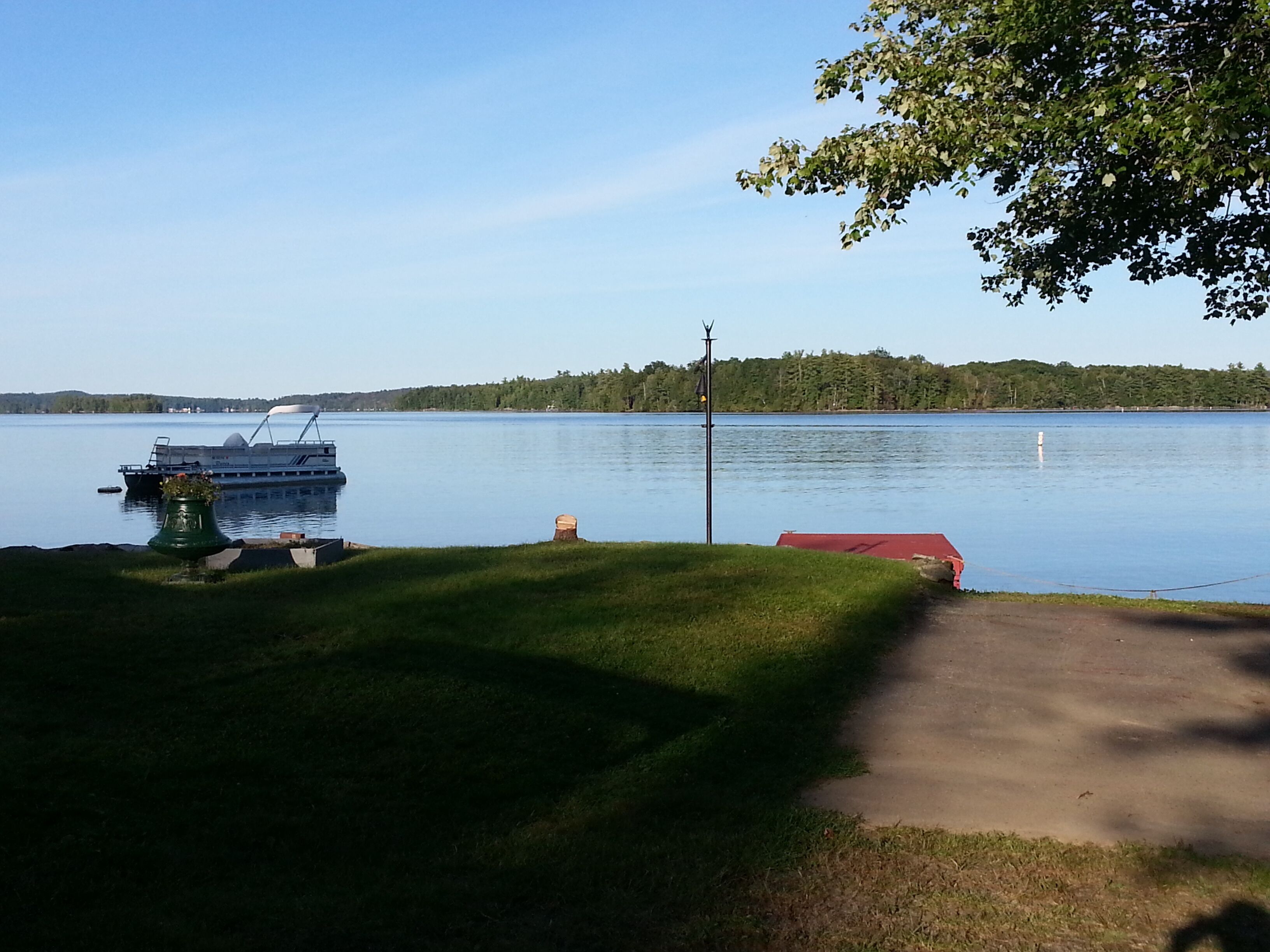 A calm lake with a dock and a boat.