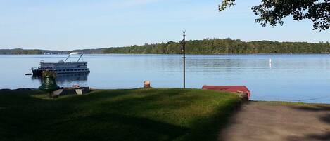A calm lake with a dock and a boat.