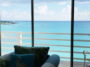 Enjoy the ocean view from this balcony with a sofa and chair, perfect for taking in the sights.