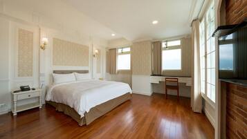 A spacious bedroom with a large bed, a desk, and a chair.