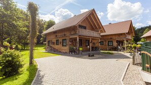 A wooden lodge with a paved driveway and a well-maintained lawn. - Landgasthof Hessenmühle (Grossenlueder)