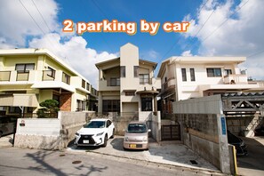 Una zona residencial con dos coches aparcados frente a un edificio.