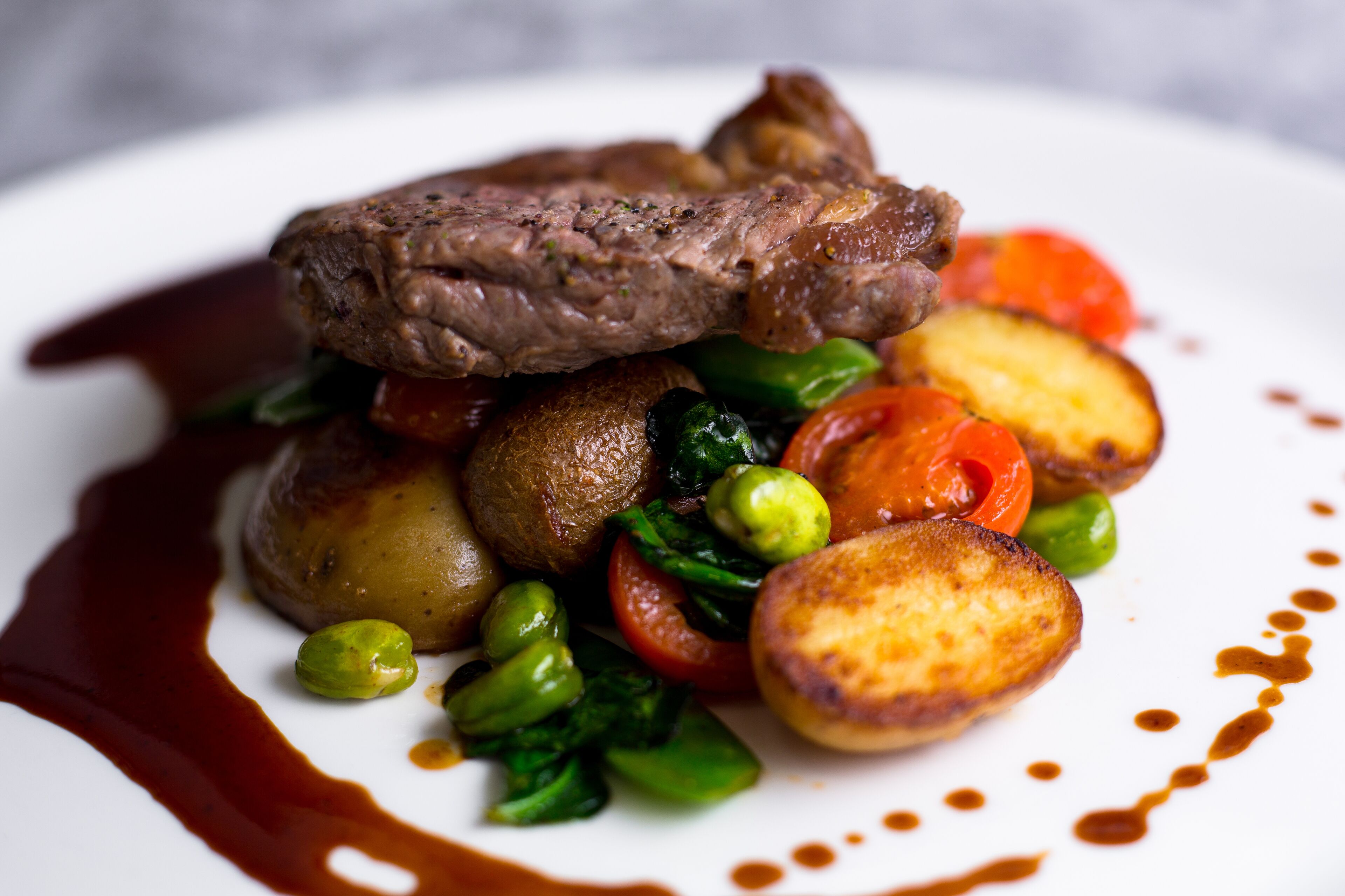 Un plato de comida con filete, papas y vegetales.