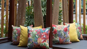A seating area with cushioned benches and floral-patterned pillows. - Nonnee (Karon)