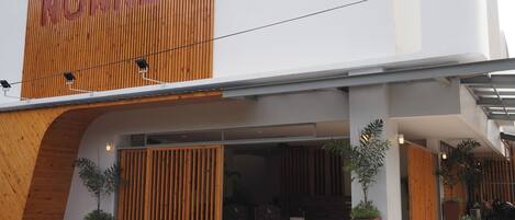 A modern building with a wooden facade and the name "NONNEG" prominently displayed.