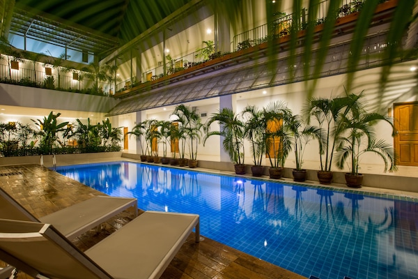 Una piscina al aire libre, sillones reclinables de piscina