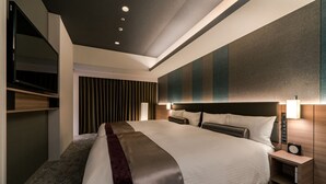 Une chambre d’hôtel moderne dotée d’un grand lit, d’une table de chevet avec une lampe, d’un téléviseur intégré et d’une armoire.