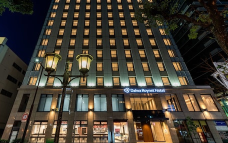 A Daiwa Roynet Hotel with a modern facade, multiple floors, and illuminated windows.