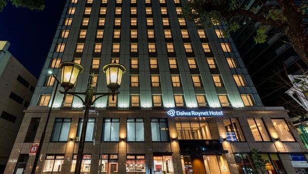 Un hôtel Daiwa Roynet doté d’une façade moderne, de plusieurs étages et de fenêtres illuminées.