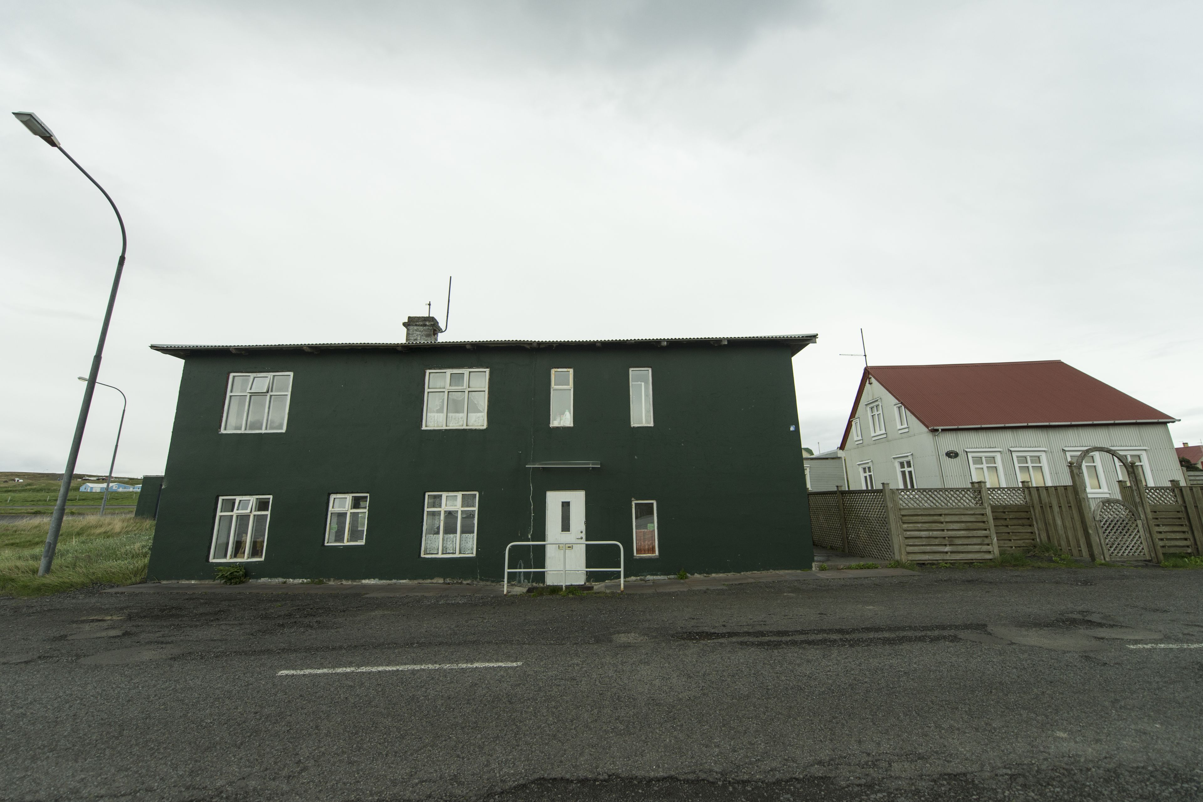 A two-story building with a green exterior and a red roof.