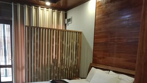 A neatly made bed with white linens and a decorative pillow. - Charming Lao Hotel (Oudomxay)