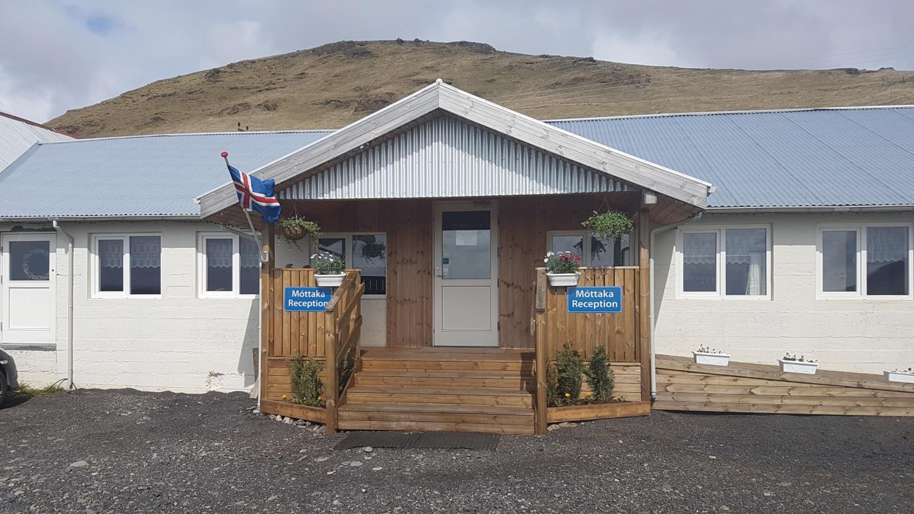 A reception area with a wooden entrance, two signs reading "Möttaka Reception," and a flag.