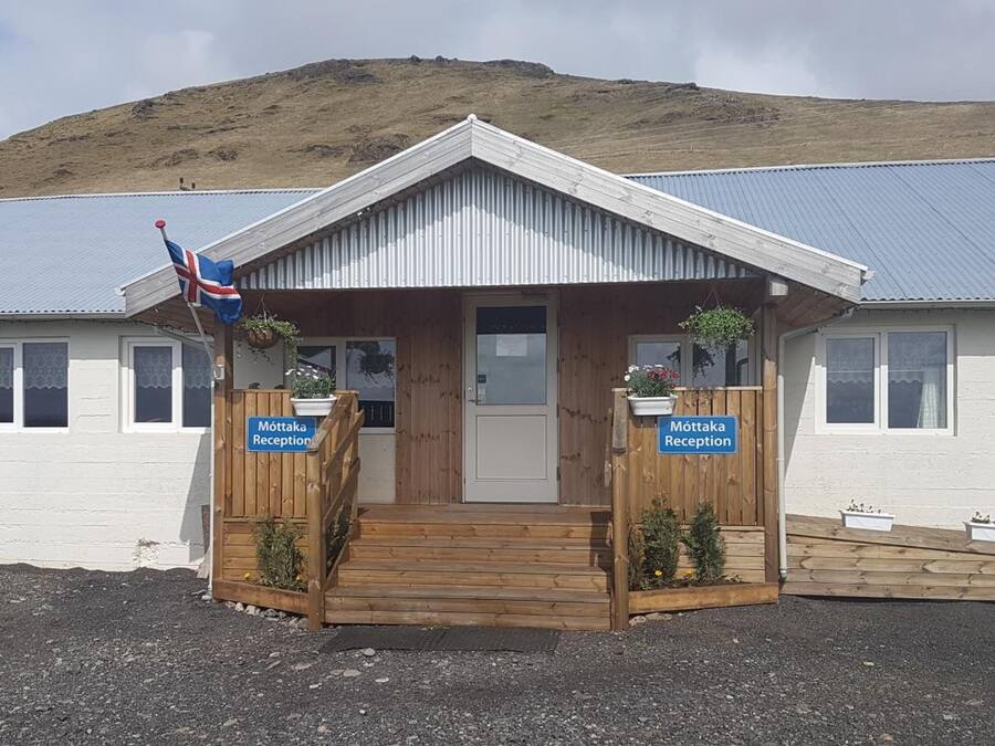 A reception area with a wooden entrance, two signs reading "Möttaka Reception," and a flag.
