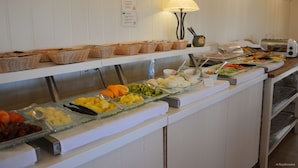 Un buffet proposant une variété de plats et d’ustensiles de service.