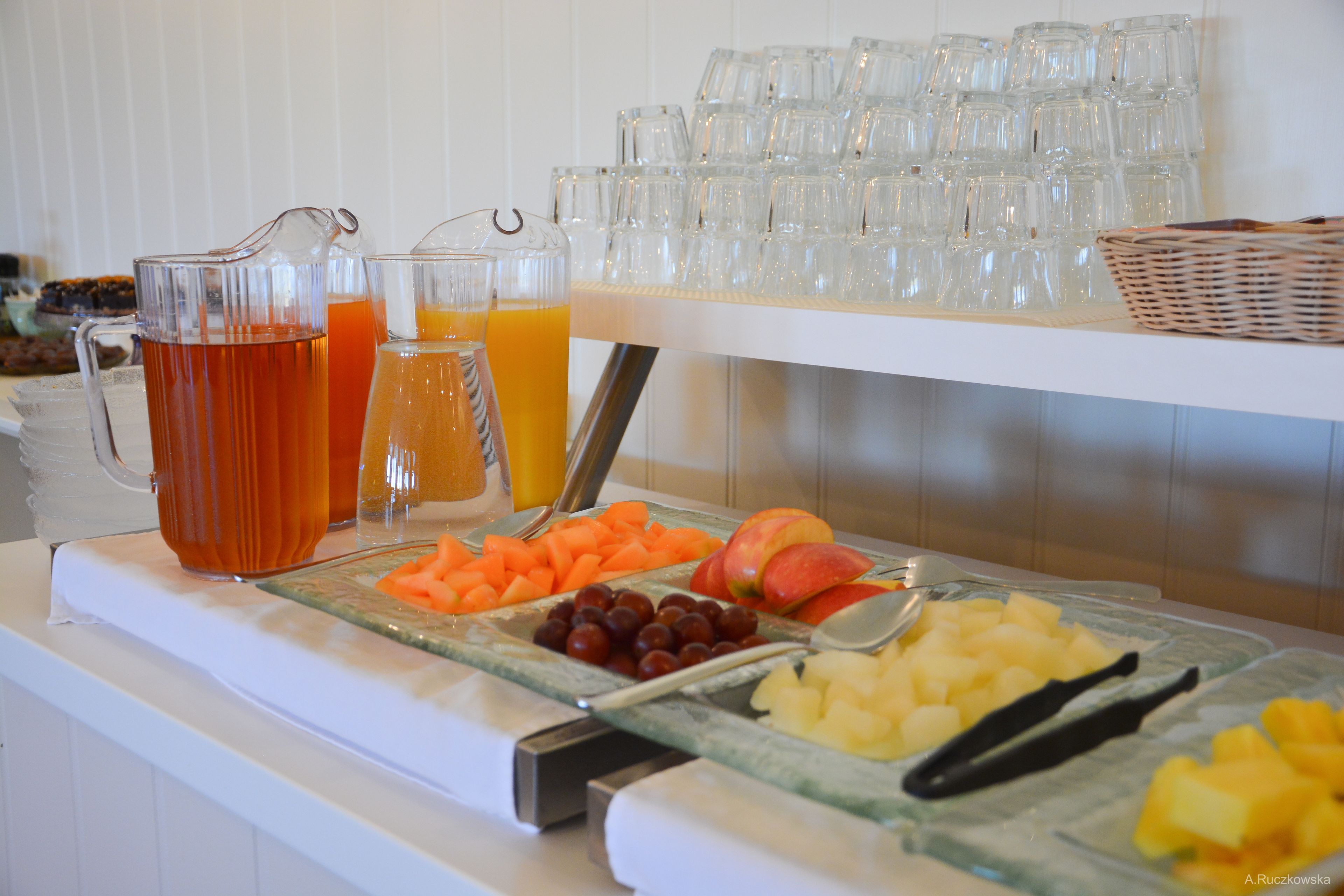 A buffet with various fruits and beverages.