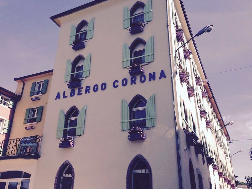 En byggnad med skylten ”ALBERGO CORONA”, vilket visar att det är ett hotell.