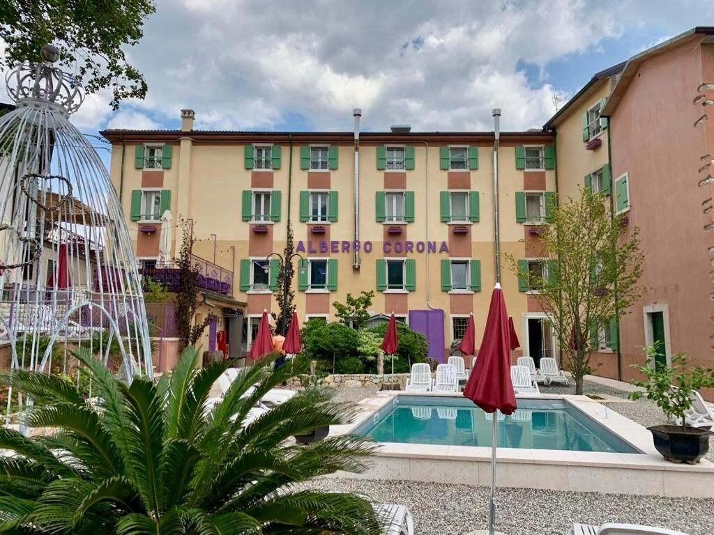 A hotel with a swimming pool, outdoor seating, and a decorative fountain.