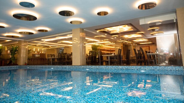 An indoor swimming pool with a tiled floor and ceiling lights. - Hotel Mansha Regency (Port Blair)