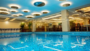 A swimming pool with a tiled floor and multiple ceiling lights. - Hotel Mansha Regency (Port Blair)