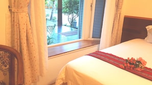 A bedroom with a bed, a window with curtains, and a view of the outdoors. - Yishingarden B&B (Shoufeng)