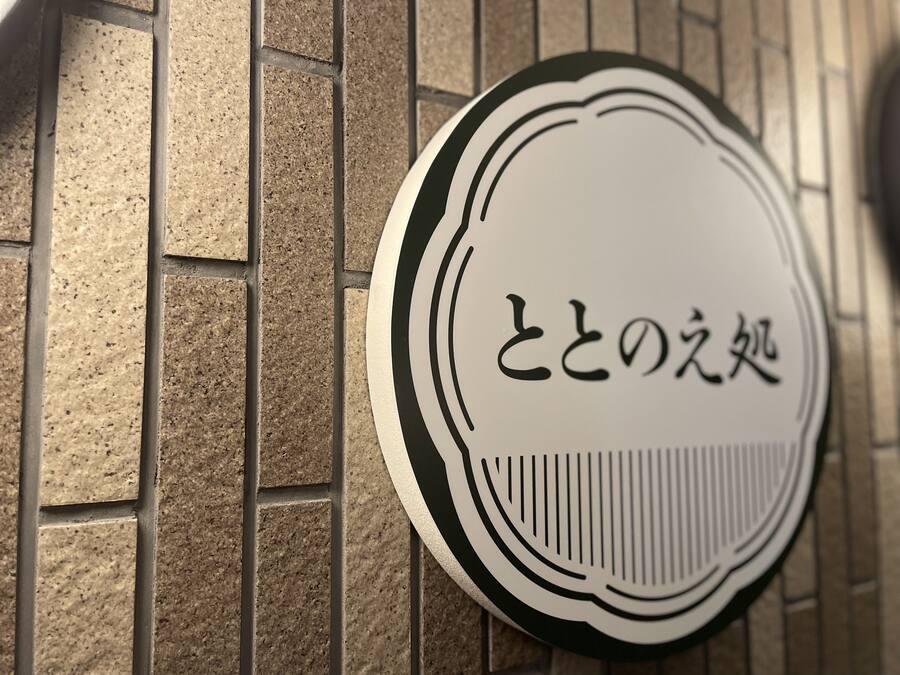 A sign with Japanese characters on a brick wall.
