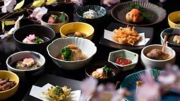 Variedad de tazones pequeños con diferentes tipos de comida, dispuestos sobre una mesa.