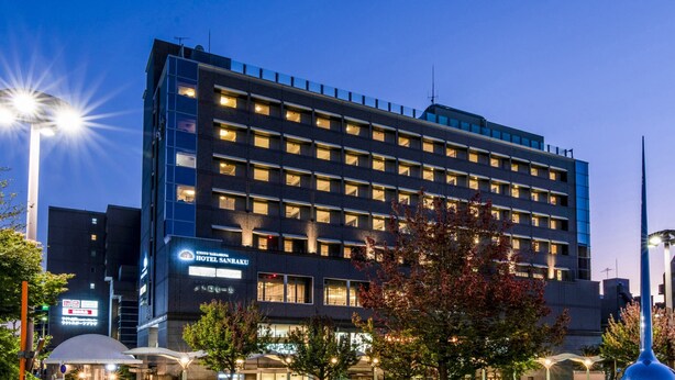 A modern hotel building with multiple floors, large windows, and a prominent sign for the hotel. - Kyoto Yamashina Hotel Sanraku (Kyoto)