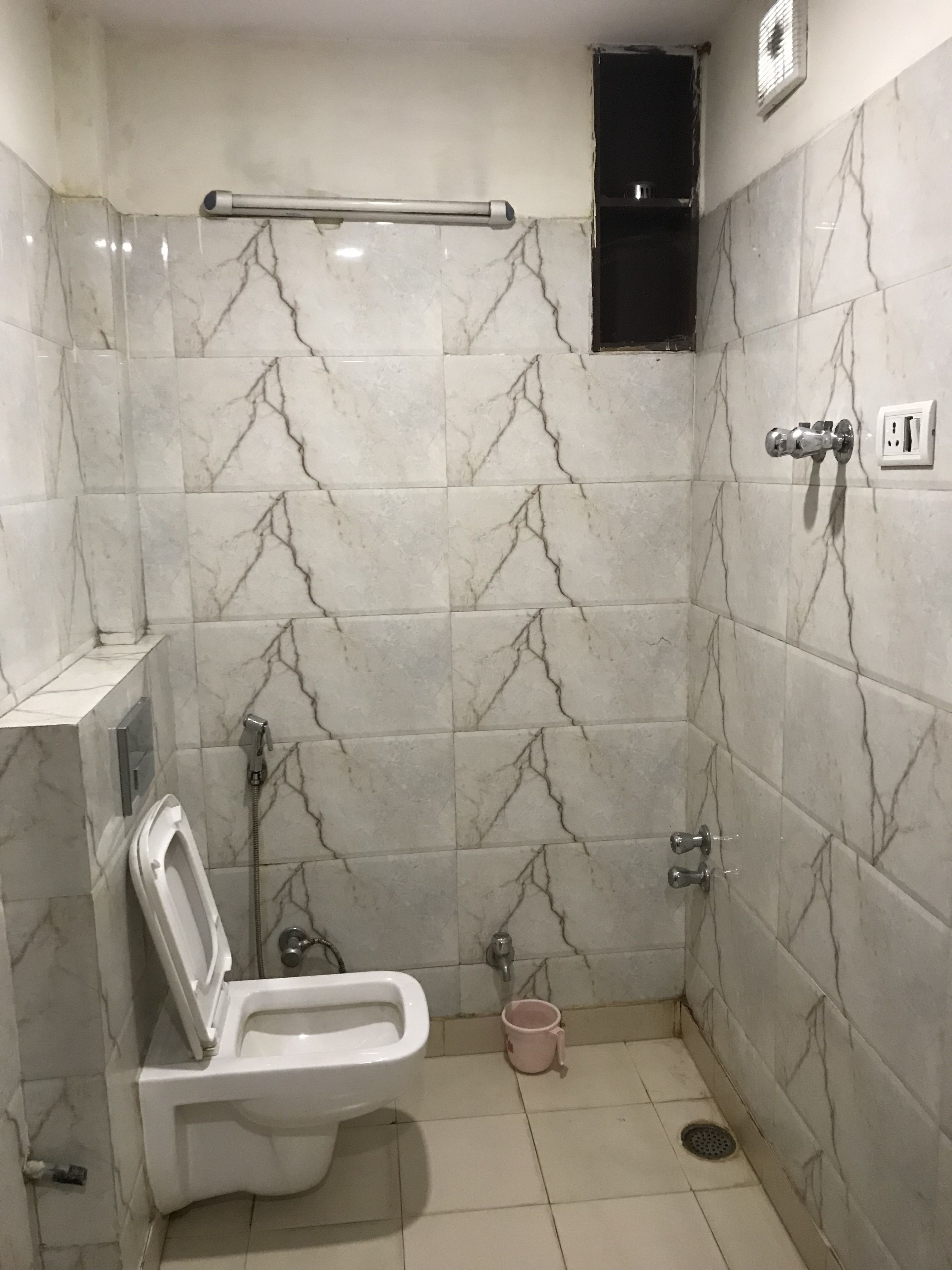 Un baño pequeño con azulejos, un inodoro, una ducha y un lavabo.