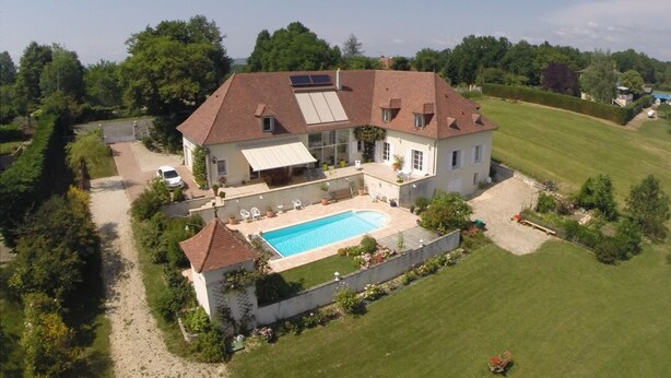 A large house with a swimming pool, a covered patio, and a well-maintained lawn. - La Maison Du Parc (Saint-Raphaël)