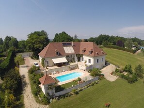 A large house with a swimming pool, a covered patio, and a well-maintained lawn. - La Maison Du Parc (Saint-Raphaël)