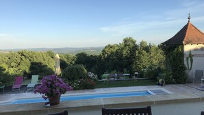 A terrace with a view of a garden and distant hills. - La Maison Du Parc (Saint-Raphaël)
