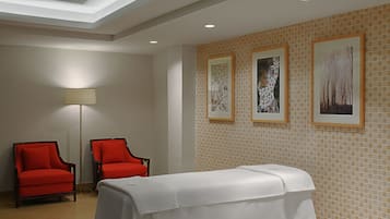 Reception area with a minimalist design, featuring two armchairs and a reception desk, surrounded by framed artwork and a tiled backsplash.