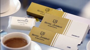 A table with toiletries including a Biotique Nourishing Soap, a Hotel & Bombay Shaving Kit, and a comb. - Hotel Bombay International (Mumbai)